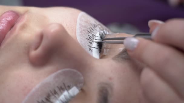 Verlenging van de wimper. de meester duwt de wimpers en lijmt nieuwe. Make-up, cosmetica. — Stockvideo