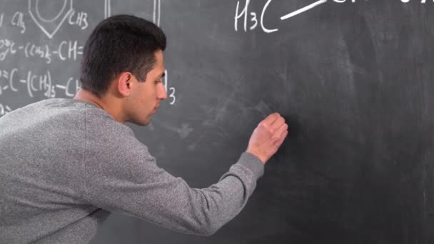 Arabic chemistry teacher writing formulas on blackboard, chemistry lecture at university, education and science for youth — Stock Video