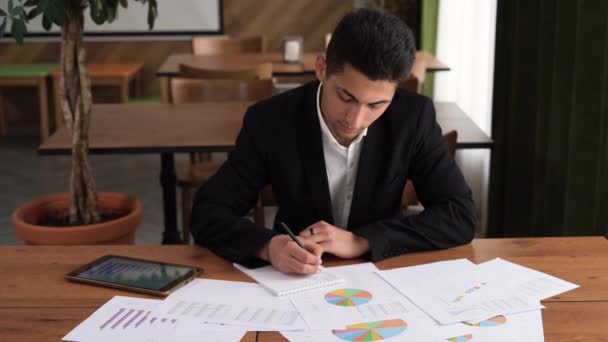 İş konsepti, iş adamı Arap genç adam çalışma masasında bir tabloyla buluşuyor, çizelgeleri inceliyor, büyüme perspektifi planlama, insanlar ve iş — Stok video