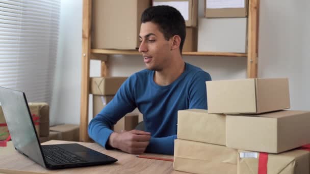 SME, handsome young arabic delivery man takes online new order from customer and picks up many packing boxes at home office, small business owner, cargo, mail, delivery — Video