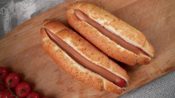 Faire cuire un hot-dog en étalant de la sauce au ketchup rouge sur une saucisse chaude grillée. Cuire en versant la sauce rouge d'une bouteille sur un hot dog. Restauration rapide. nourriture américaine — Video