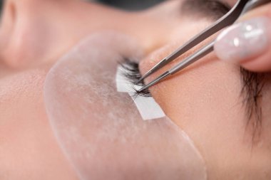 Kirpik uzatma prosedürü. Kirpikli bir kadın gözü. Kirpikleri, yakın çekim, makro, seçici odak.