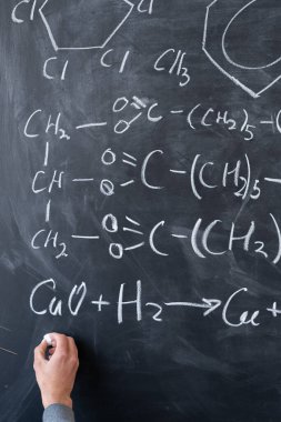 Erkek el çizimi tebeşir formülleri ve karatahtadaki elementler, kimya işaretleri ve sembolleri, kimyada maddelerin incelenmesi kavramı.