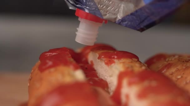 Close-up do processo de preparação de um cachorro-quente, chef derrama mostarda — Vídeo de Stock