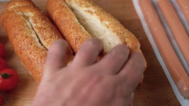 Sosisli pişirmek, sosisliye ketçap dökmek, sosisleri paketlemek, ahşap bir arka planda fast food pişirmek.