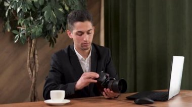 Arap genç fotoğrafçı kameradan hafıza kartını çıkarıyor. Kafede dizüstü bilgisayarla çalışan bir adam. Bir fotoğrafçı dosyaları fırlatıp atıyor.