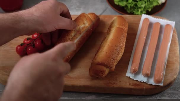 Šéfkuchaři ruce krájení hot dog houska s nožem, americké jídlo, rychlé občerstvení doma, muž vaření — Stock video
