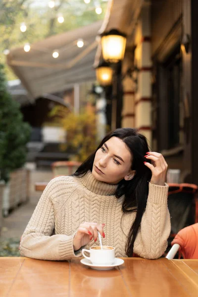 Young Beautiful Caucasian Woman Sits Cafe Sweater Stirs Sugar Coffee — стоковое фото