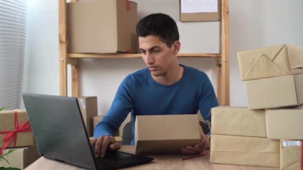 KOBİ, yakışıklı Arap teslimatçı müşteriden yeni siparişleri alır ve ev ofisinden, küçük işletme sahibi, kargo, posta, teslimat gibi pek çok kutu alır. — Stok video