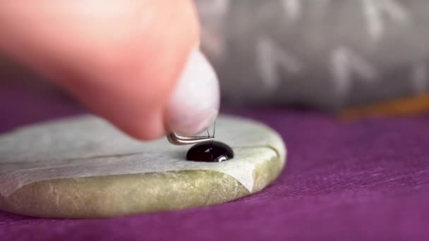 Eyelash extension process, master dipping an eyelash into a special glue in a beauty salon, macro eyelashes — Stock Video