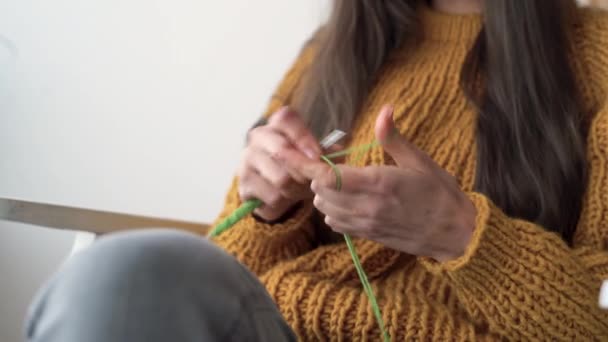 Crochet with your own hands. Knitting with green threads. Womens hands hold a hook and knit.Do it yourself. Creativity lessons. hobby — Stock Video