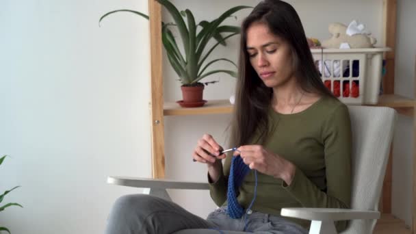 Latin hemmafru virkning sittande i en stol, sticklektion, kvinna hobby och fritid, kvinna handarbete — Stockvideo