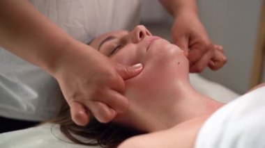 Spa salonunda yüz masajı, masör yenileme prosedürü, masaj odası, sağlıklı yüz derisi.