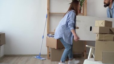 Taşınma ve taşınma konsepti, karton kutular arasında büyük bir kutu taşıyan mutlu ve evli bir çift, mülk almaktan zevk alıyor, yeni bir daireye taşınmakta sorunlar yaşıyor.
