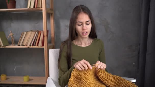 Tejer lana. Mujer joven latina teje ropa de casa de hilos de lana. costura, creación de accesorios y ropa hechos a mano a partir de materiales y tejidos naturales, hobby y ocio — Vídeos de Stock