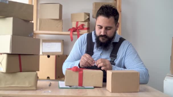 Indù imprenditore maschile che lavora da casa in uniforme con scatola di imballaggio sul posto di lavoro - acquisto o vendita on-line concetto. attacca un codice a barre su una scatola artigianale — Video Stock