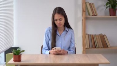 Sofra işi konseptinde akıllı telefonu olan bir kadın. Aylık ev giderleri, vergiler, banka hesap bakiyesi ödemeleri,