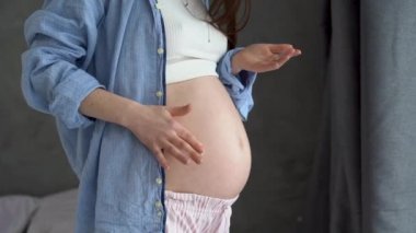 Hamilelik ve cilt bakımı, karnına krem süren hamile bir kadın, hamilelik ve güzel bir cilt.