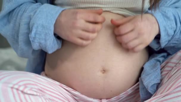 特写孕妇抚摸她的肚子，孕妇在等孩子，代孕母亲在床上休息，母性和怀孕 — 图库视频影像