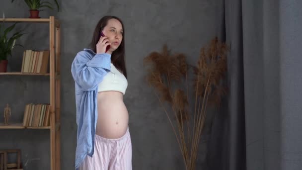 Discomfort during pregnancy. Pregnant woman with back pain, backache, doctor call, girl with belly holds lower back, pregnancy and health — Stockvideo