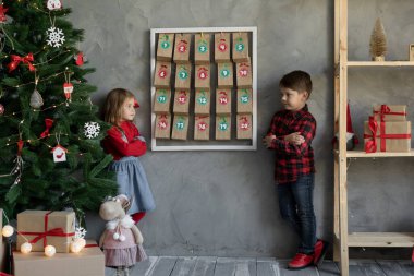 El yapımı takvimde küçük kardeş portresi, Noel dekoru olan çocuklar, Noel hayranı çocuklar.