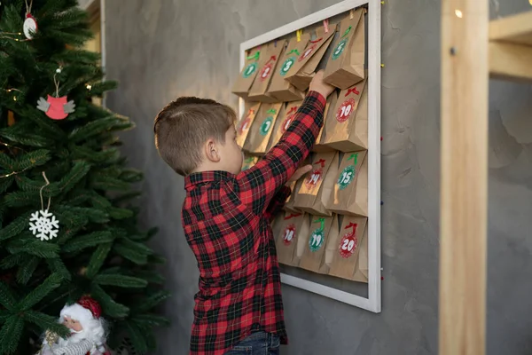 Çocuk hediye alıyor, el yapımı takvim günü şekerli el işi çantalardan. Çevre dostu Noel, sıfır atık, çocukların mevsimlik aktiviteleri, Noel gelenekleri konsepti
