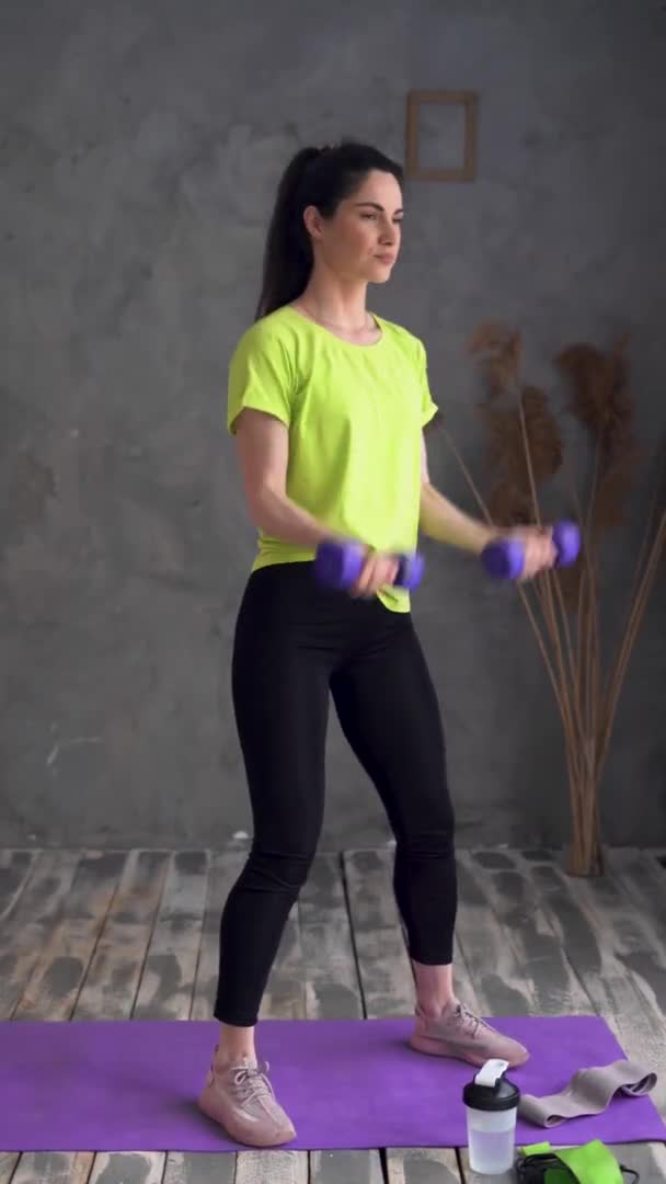 Home fitness of athletic woman at home, sports exercises with dumbbells for slender arms, strong biceps, sport and healthy lifestyle — Stockvideo