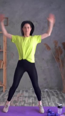 Active athlete young woman exercising and jumping at home, cardio workout, sport, fitness and healthy lifestyle, vertical video 4K