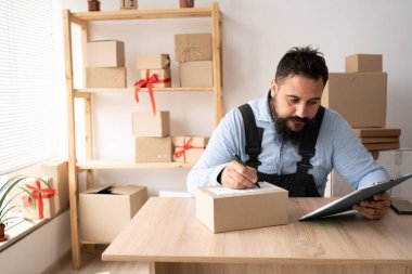 Start up entrepreneur of indian millennial man with box for packaging order from shopping online working at home office, small business owner making order delivery, small business shipping concept