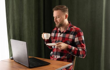 Yakışıklı erkek tasarımcı kafeterya kahvesi içiyor ve dizüstü bilgisayarla yeni bir proje üzerinde çalışıyor, milenyum öğrencisi internette kahve molası veriyor, iş adamı evlerinin önünde günlük kıyafetlerini giyiyor.