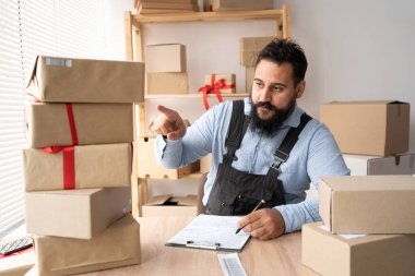 Online Sales Shipment, Small Business Owner Delivery Service. Business owner revises credit calculation. Post office. indian seller or postman in home warehouse