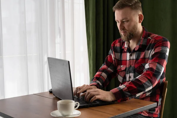 Günlük giyim sektöründe serbest çalışan biri bir kafede otururken dizüstü bilgisayar kullanır, içeride uzaktan çalışma, çevrimiçi kazanç, bilgisayar uygulamaları, online iş konsepti