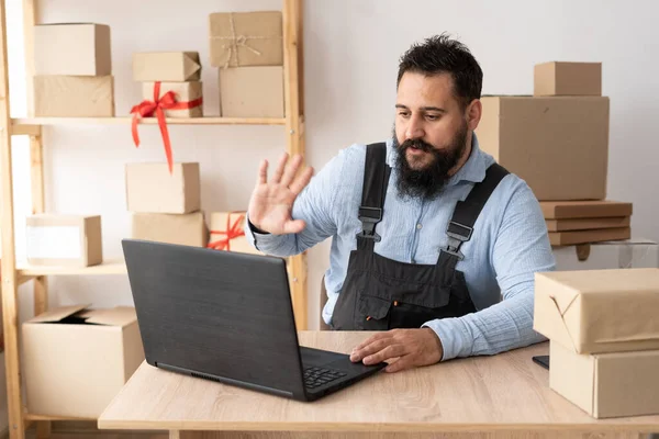 Small business startup entrepreneur or freelance indian man using laptop with box, young businessman with hand raised, online marketing packaging box and delivery, SME concept.