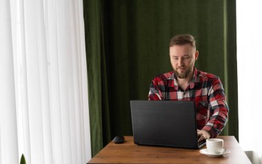 İş adamı, kahve fincanı olan bir açık kafede dizüstü bilgisayar kullanıyor. Uzaktan kumandalı bilgisayar, online iş, serbest iş için kablosuz internet, iş kavramı, fotokopi alanı, metin için yer.