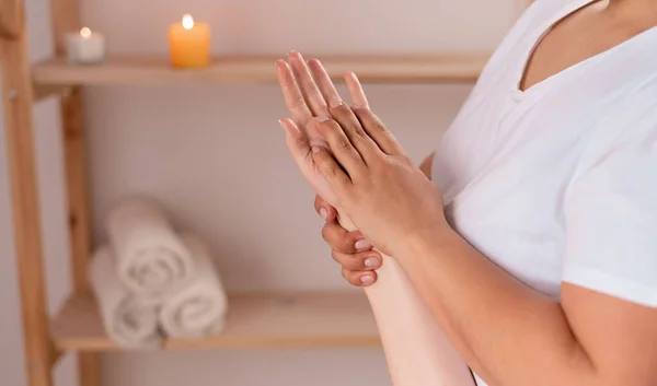 woman hands massage in spa salon, masseur massaging hand and fingers for relaxation, alternative medicine, muscle weakness treatment, health and massage concept