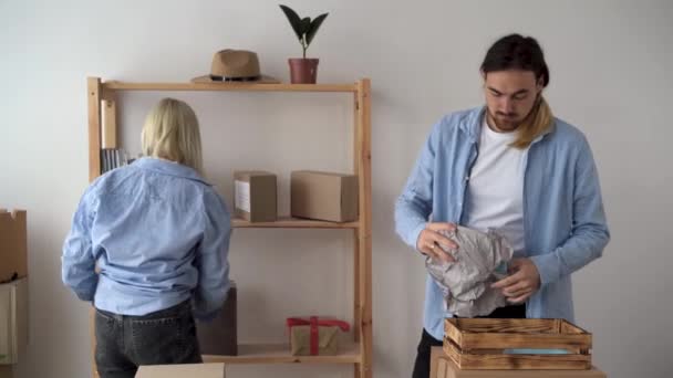 Young family moving to new apartments, hipster couple moving to new house, packing things in boxes, relocation — Stock Video