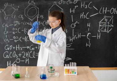 Beyaz önlüklü genç kız kimyager bir kimya dersinde kimyasal bir deney yapıyor. Okuldaki kadın kariyer konseptine geri dönüyor.