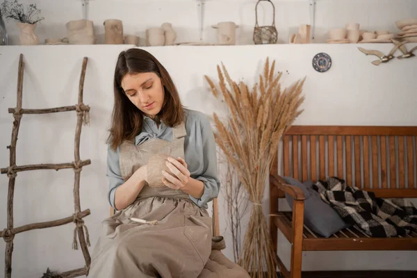 woman artist sculpts from wet clay in studio. ceramist makes handicrafts from ceramics. female industriousness concept. copy space.