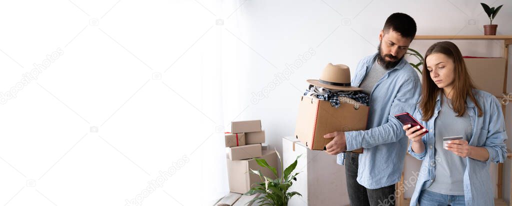 SME freelance woman hand holding credit card and smartphone with boxes, couple moving in new home, online marketing packaging mail box and delivery, SME e-commerce concept, banner, place for text