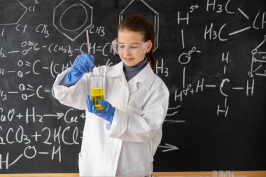Bilim deneyi yapan kız öğrenci ya da kimya laboratuvarında kimyasal reaksiyon. Dahi çocuk kavramı, zeki ve zeki..