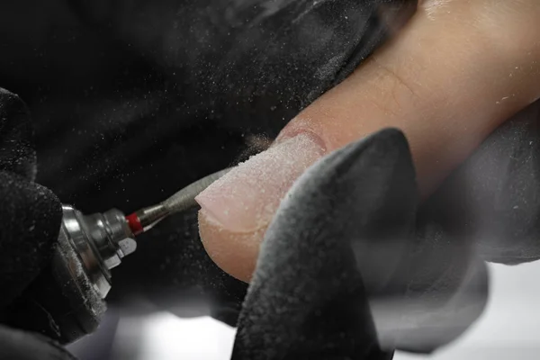 五金美容院修指甲的过程 美甲师的手使用自动电动美甲钻从客户的指甲上取出指甲油 — 图库照片