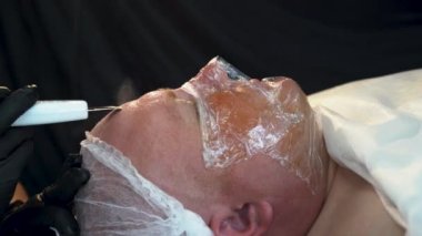 Ultrasonik ovma. Donanım kozmetolojisi. Adam ultrason kabuğu soyma ve yüz temizleme ameliyatı alıyor. Yüz bakımı, yüz temizleme. Kozmetoloji kavramı