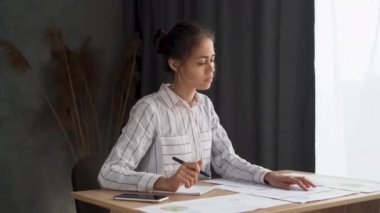 Dosyalarla, belgelerle, kağıtlarla ve kitaplarla çalışan odaklanmış bir kız. Evde ödev yapan ciddi bir lise öğrencisi. Eğitim, öğrenme, sınav konseptine hazırlanma