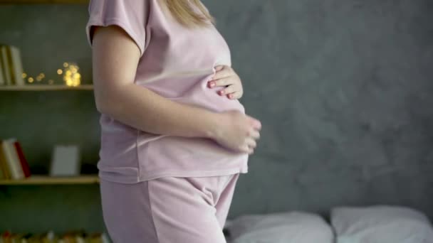 Ευτυχισμένη Έγκυος Που Χαϊδεύει Την Κοιλιά Της Κοντά Στο Παράθυρο — Αρχείο Βίντεο