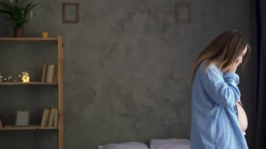 Evde cep telefonu, hamilelik ve teknoloji kavramı olan güzel hamile bir kadın.
