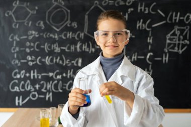 Laboratuvarda deneyler için kimyasallar içeren Erlenmeyer şişesine bakan bilim adamlarının portresi, okul kimyası. Eğitim kavramı
