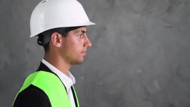 不满的阿拉伯男性工头或建筑师把扩音器放到嘴里 开始大喊大叫 建筑商戴着白色头盔和黄色背心 特写肖像 — 图库视频影像
