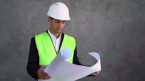 混凝土背景上年轻的Arab建筑师 建筑商拿着一些文件 在建筑办公室工作 采石场设计师兼建筑商经验丰富的工作服建造者 — 图库视频影像