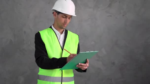 年轻工作的Arab土木工程师使用平板电脑计划一个项目 建造一个现代化的建筑 阅读一个计划 在建筑工地工作的建筑或工程师 — 图库视频影像