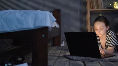 Veri merkezinde monitör ekranı olan dahi çocuk bilgisayar korsanı. Dijital cihazlar kullanan çocuklar. Evde dizüstü bilgisayarı olan küçük bir kız öğrenci, çocuklar ve teknoloji konsepti